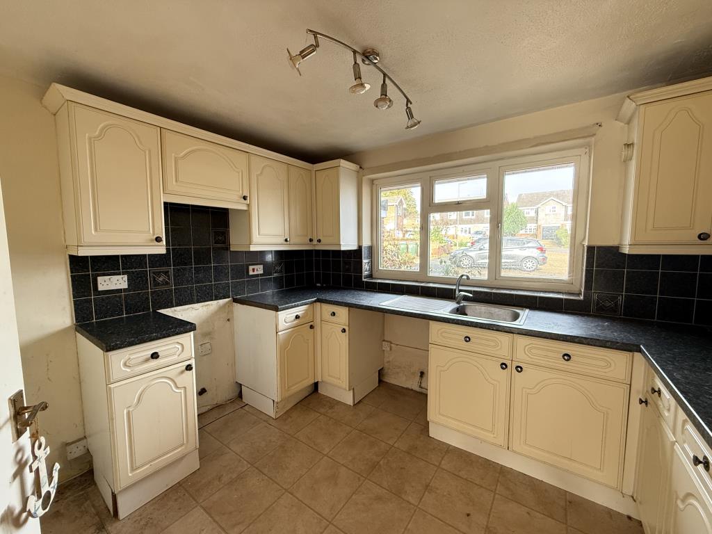 Lot: 73 - THREE-BEDROOM SEMI-DETACHED HOUSE WITH GARAGE IN NEED OF IMPROVEMENT - Fitted kitchen looking onto driveway